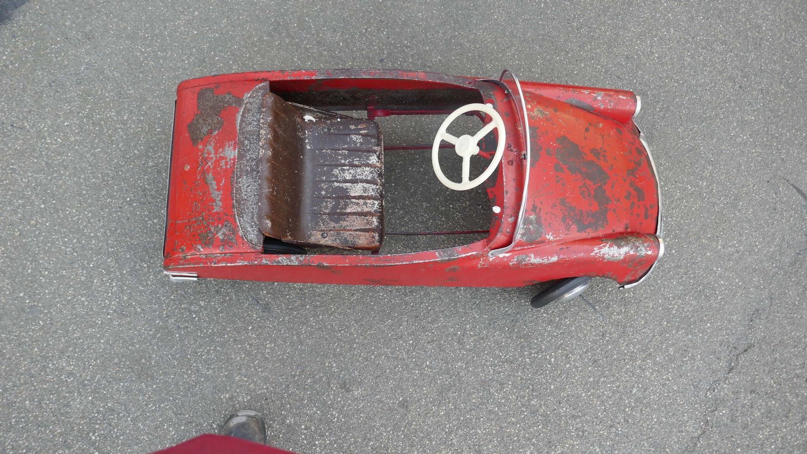 Ein rotes Spielzeugauto mit weißem Lenkrad